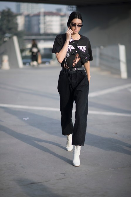 Kendall Jenner Style: Kendall Jenner wearing a simple band T-shirt, black pants and white sneakers at Milan Fashion Week in 2017.