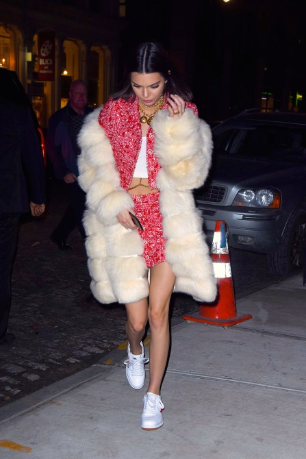 Kendall Jenner Style: Kendall wearing an oversized white faux fur coat over a pink skirt suit in New York City in 2017.