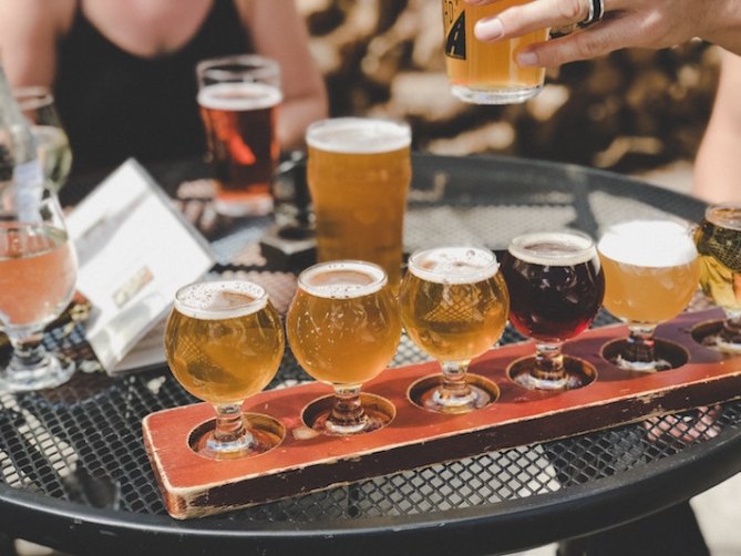 A flight of beer next to several other glasses of beer