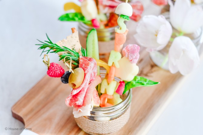 A jar filled with charcuterie and cut up fruit
