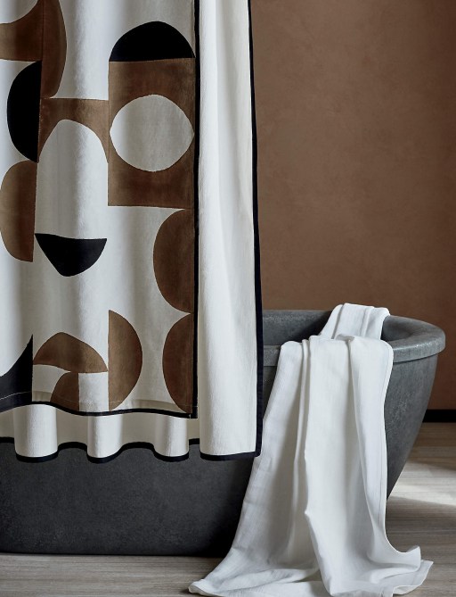 Two layered shower curtains hung over a stone tub