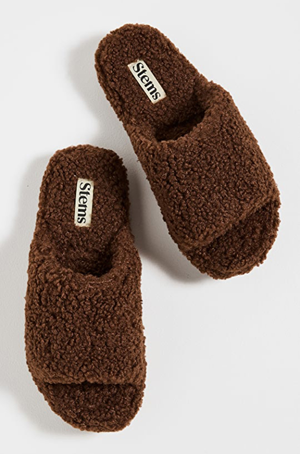 A pair of fuzzy slip-on sandals lined with brown bouclé fabric