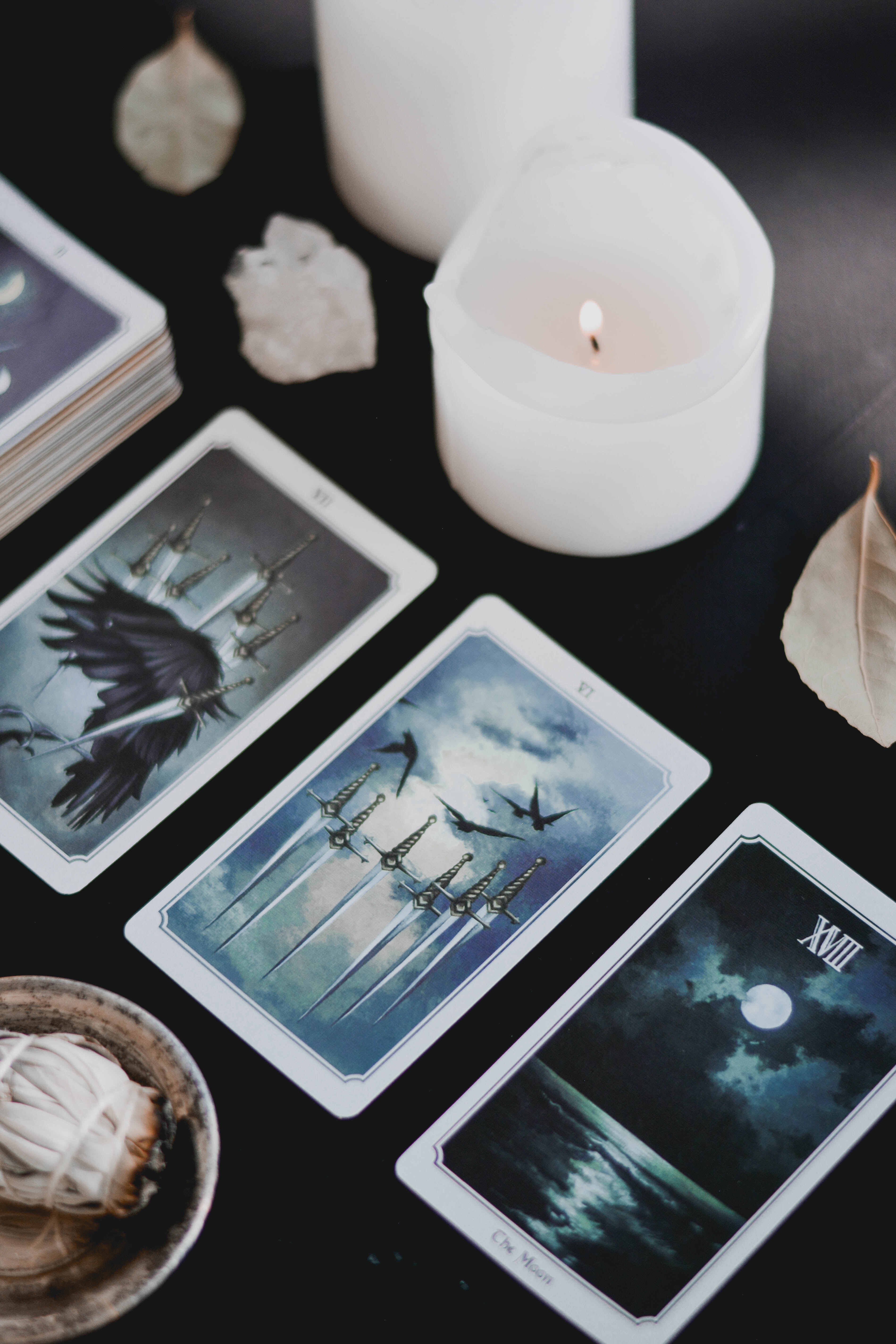 Oracle cards, candles, and crystals on a table
