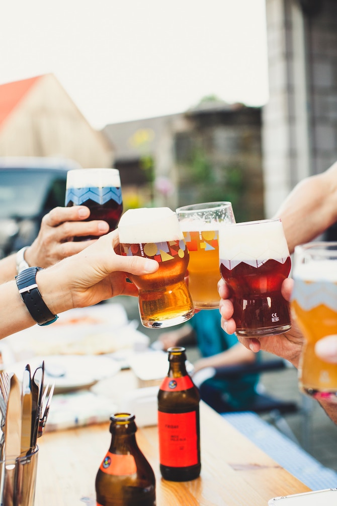 A group of people cheersing beer at an outdoor bar