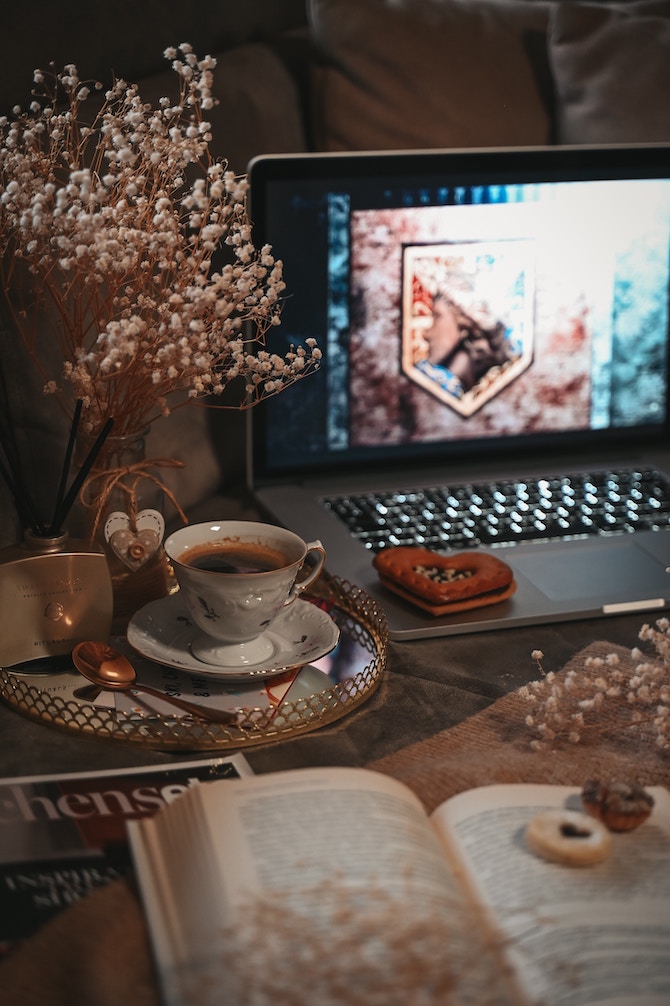 A fairytale-like scene with flowers, tea, and an open book