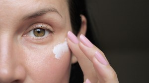 A woman applying eye cream