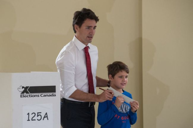 Canadian Liberal Party leader Justin Trudeau walks with his son Xavier to cast his ballot in Montreal on October 19, 2015.