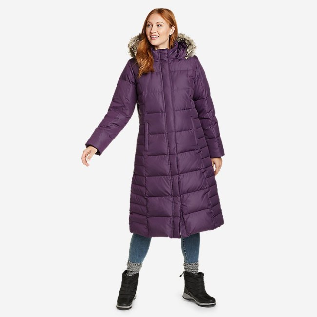 A woman wearing the Eddie Bauer Women's Lodge Down Duffle Coat in purple