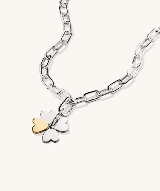 A silver chain-link necklace with a silver and gold four leaf clover charm