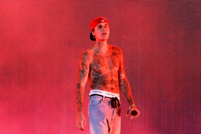 Justin Bieber shirtless with tattoos performing on stage at Coachella.
