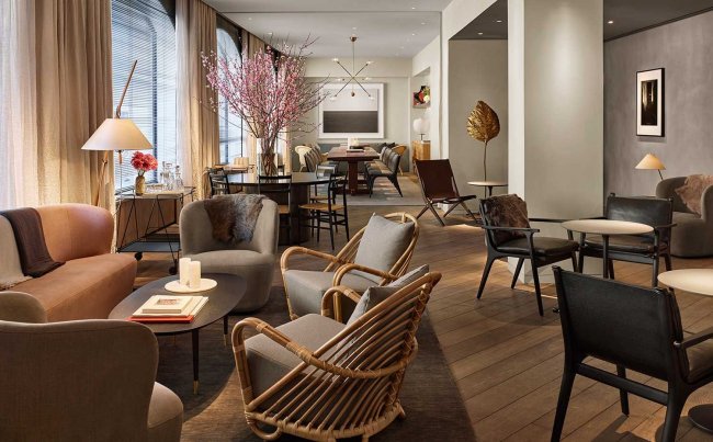 The lobby at 11 Howard hotel, which features several small seating areas and a long dining room table