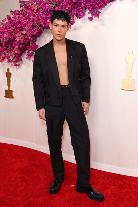 Omar Rudberg at the 2024 Oscars red carpet shirtless in a black suit