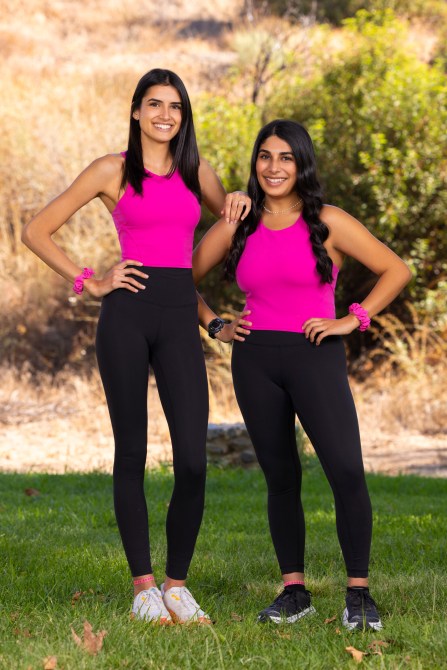 Kishori Turner and Karishma Cordero, two South Asian women wearing matching pink and black athletic wear.