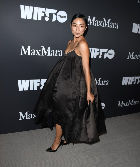 Greta Lee in a poofy black evening gown a the WIF Honors red carpet