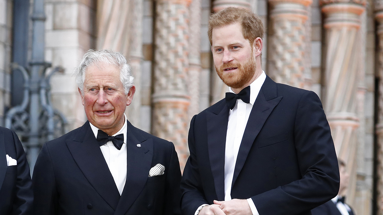 King Charles, a white man with white hair wearing a tuxedo with Prince Harry, a white man with red hair and beard in a tuxedo.