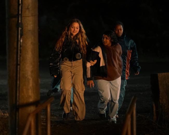 In 1997, on a quiet island in BC, fourteen-year-old Reena Virk attends a party and never returns home. Her disappearance intrigues a novelist returning to her hometown, who finds herself drawn into the hidden world of the teen suspects… Josephine (Chloe Guidry), Reena (Vritika Gupta) and Dusty (Aiyana Goodfellow), shown.