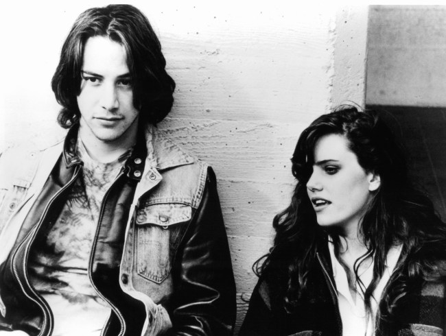 Keanu Reeves stands against a wall with Ione Skye in a scene from the film 'River's Edge', 1986.