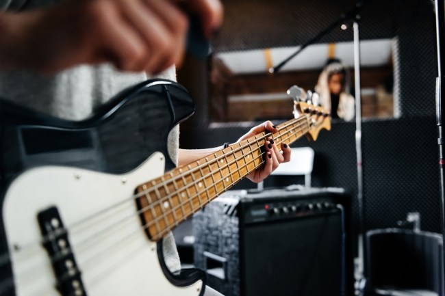 Close-up shot of a musicians hand playing a guitar in a record studio