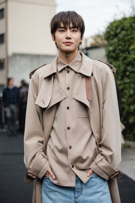 Jungwoo, wearing a beige trench coat and shirt, is seen outside Tod's show during the Milan Fashion Week Menswear Spring/Summer 2025 on September 20, 2024 in Milan, Italy.