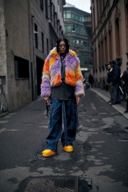 a milan fashion week guest in a fur coat and jeans