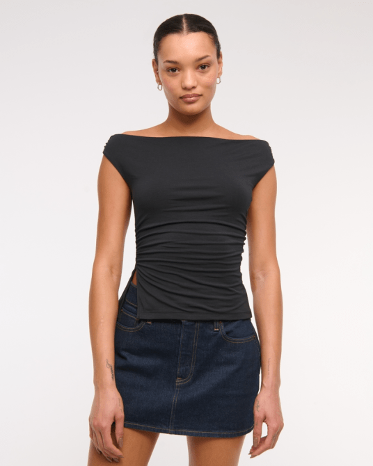 A model wearing the Abercrombie & Fitch Draped Off-The-Shoulder Top in black