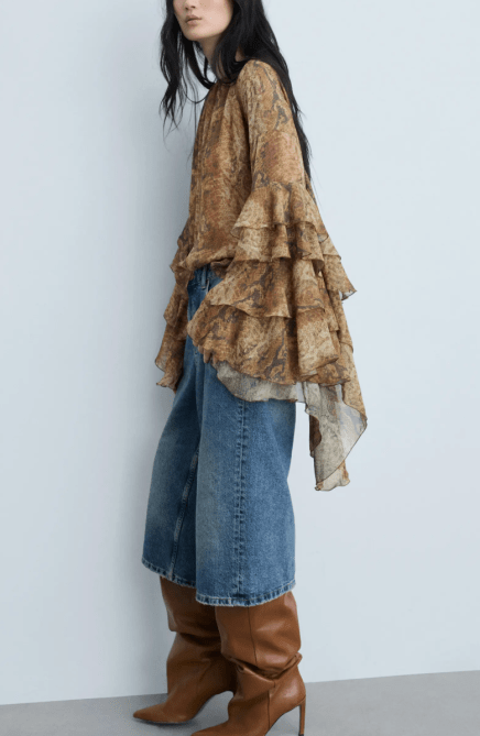 A model wearing the Mango Carola Tiered Bell Sleeve Chiffon Top in a reptilian print