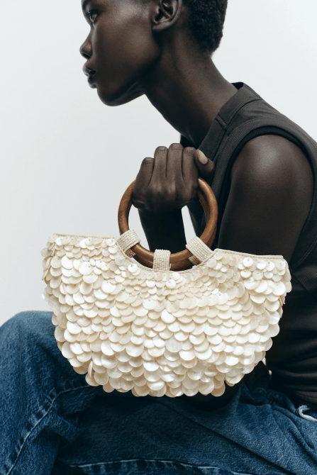 A model holding the Zara Faux Mother of Pearl Appliqué Bag in pearl gray