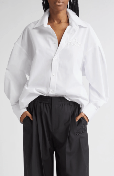 A model wearing the Alexander Wang Embroidered Logo Oversize Button-Up Shirt in white