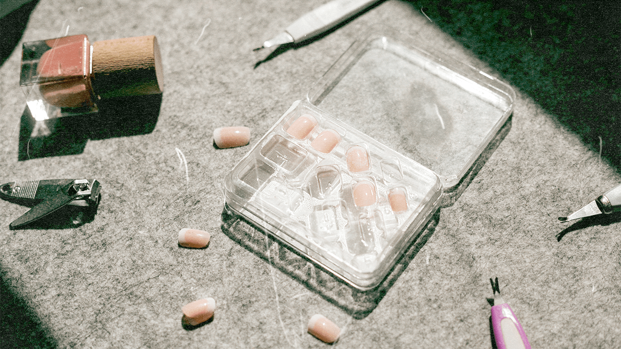 Press-on nails, a nail polish bottle, and nail tools.