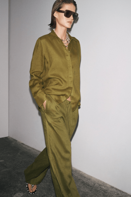 A model wearing the Zara 100% Linen Palazzo Pants in an olive green colorway