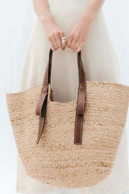 A model holding the Zara Woven Shopper Bag
