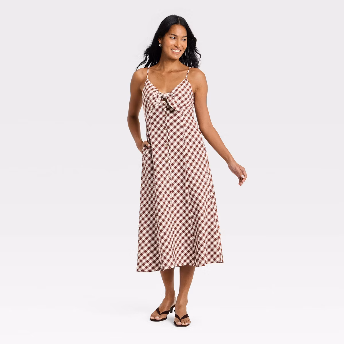 A woman wearing a gingham midi dress