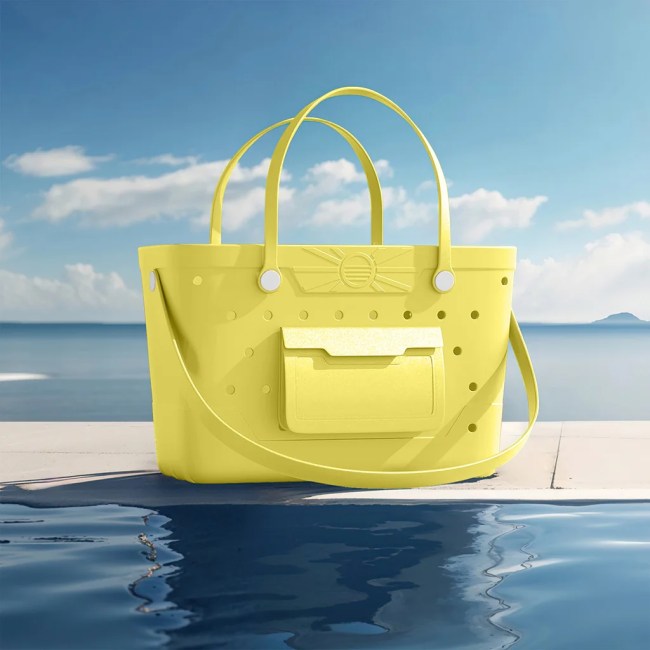 Yellow rubber beach bag sitting poolside with a blue sky in the background