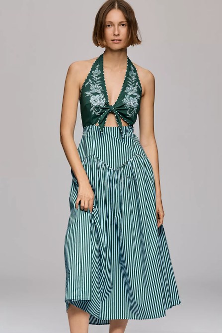 A woman in a green cut-out halter dress.