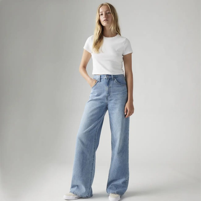 A woman in blue baggy jeans and a white t-shirt