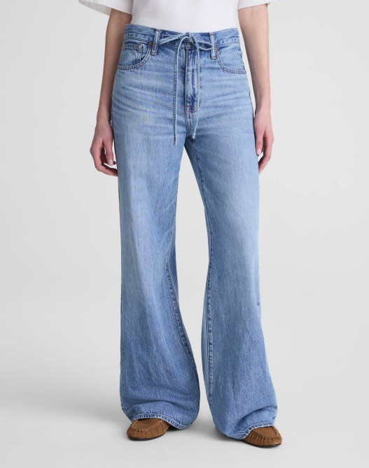 A woman wearing blue jeans with a drawstring.