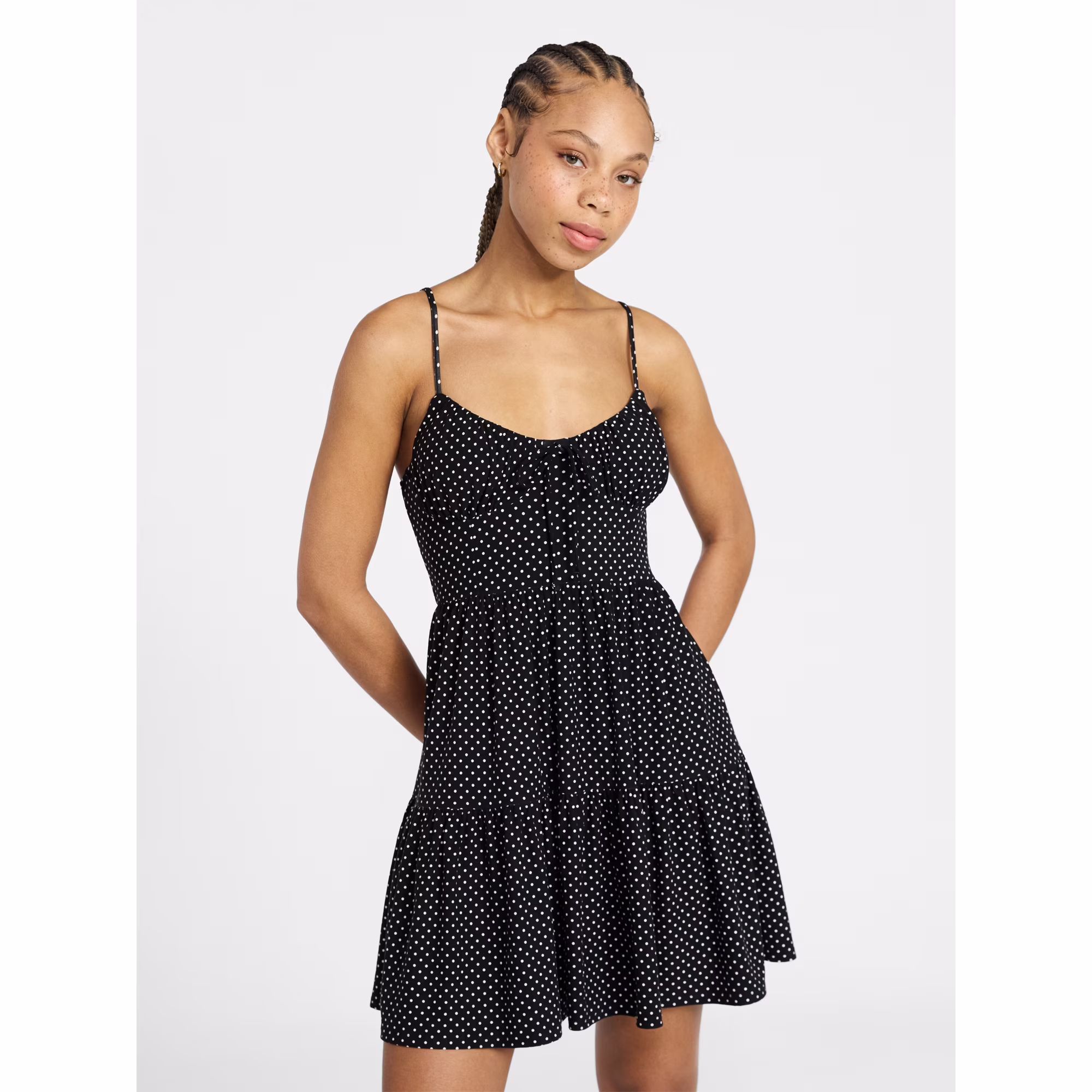 A woman wearing a black ruffled mini dress.