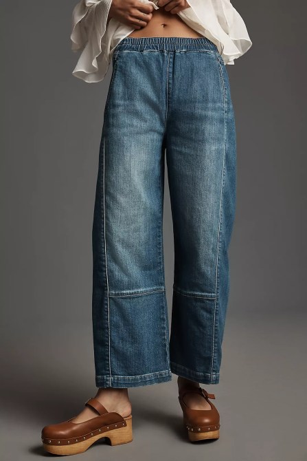 A woman wearing blue pull-on jeans with brown clogs