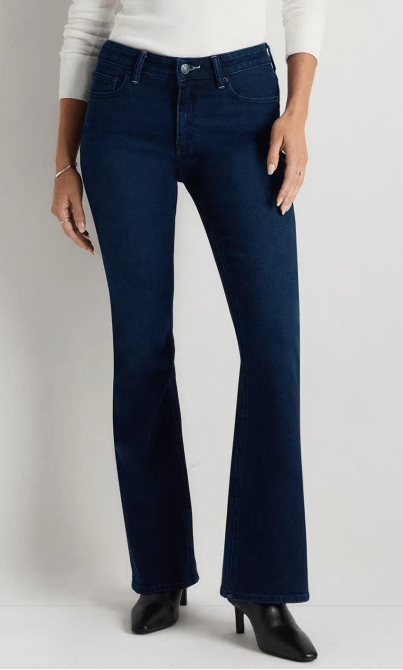 A woman wearing navy blue flare jeans