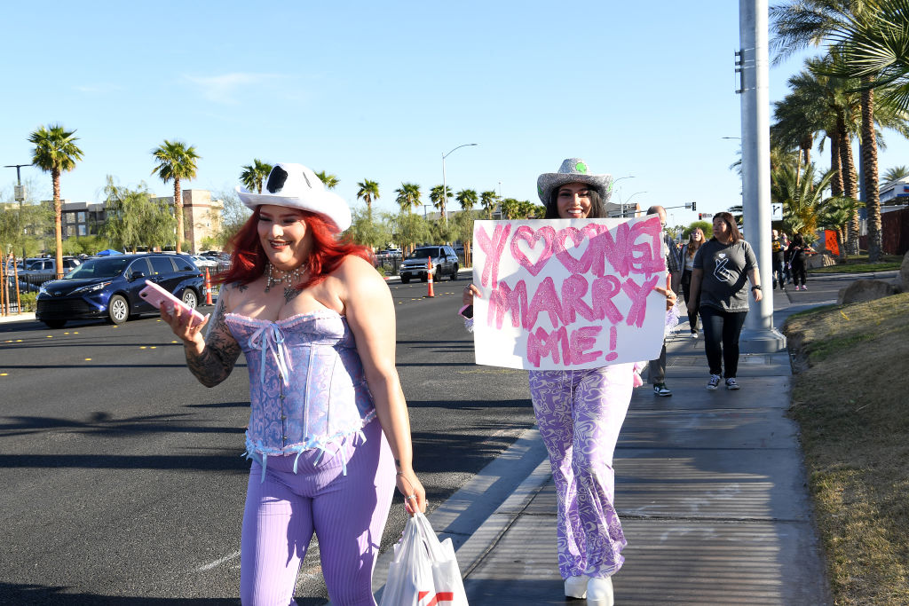 LAS VEGAS, NEVADA - APRIL 08: BTS fans Amalia Torres and Evonne Torres of California, carry a sign made for the BTS concert tonight April 08, 2022 in Las Vegas, Nevada. The K-Pop band kicks off four shows at Allegiant Stadium tonight, which marks their first U.S. concert since the COVID-19 pandemic shutdown. (Photo by Denise Truscello/Getty Images).