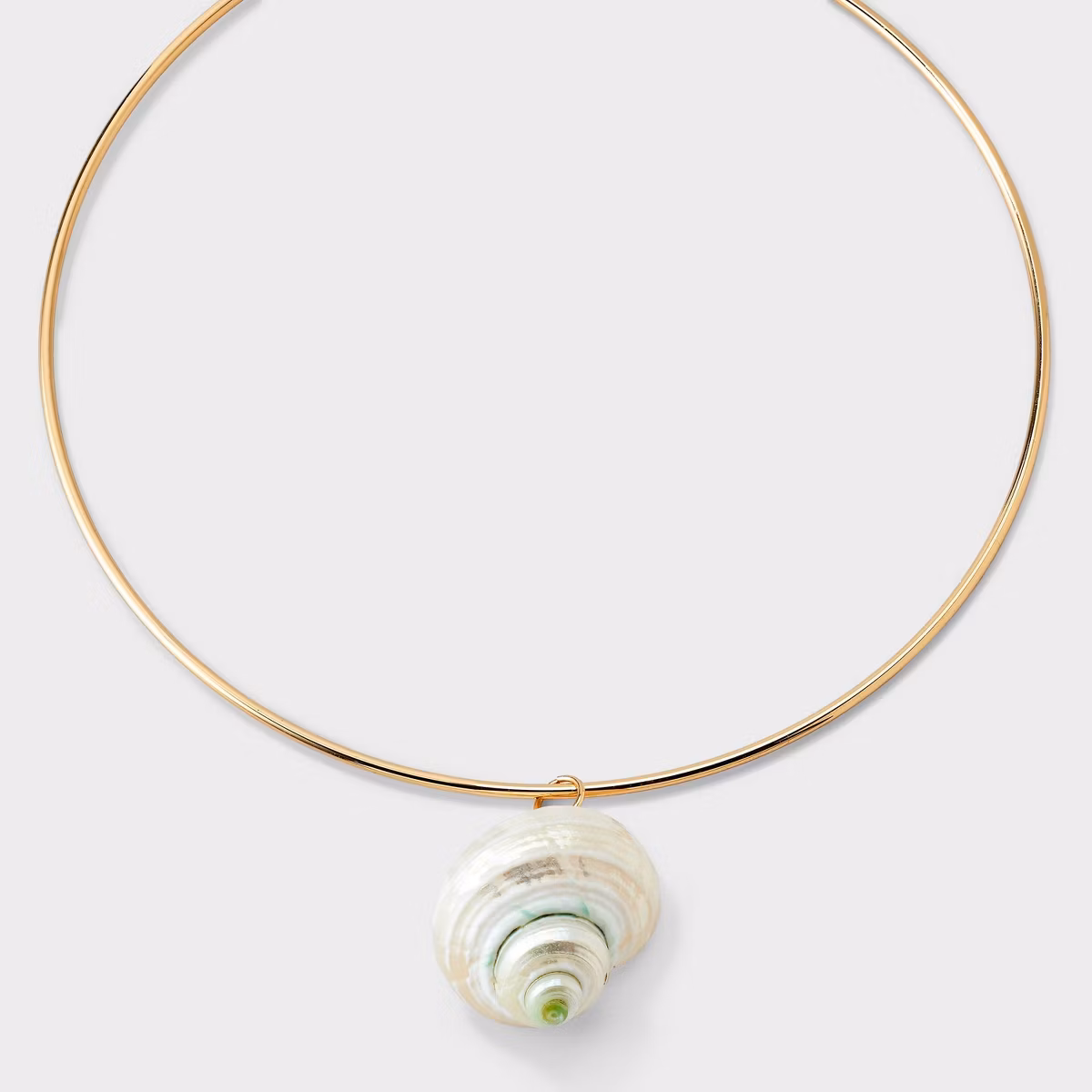 A gold choker necklace with a shell pendant