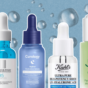 A blue background with water droplets and four hyaluronic acid serum bottles from La Roche-Posay, Curology, Kiehl's, and OSEA